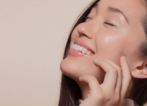 Happy woman touching her face after Bela MD+ treatments